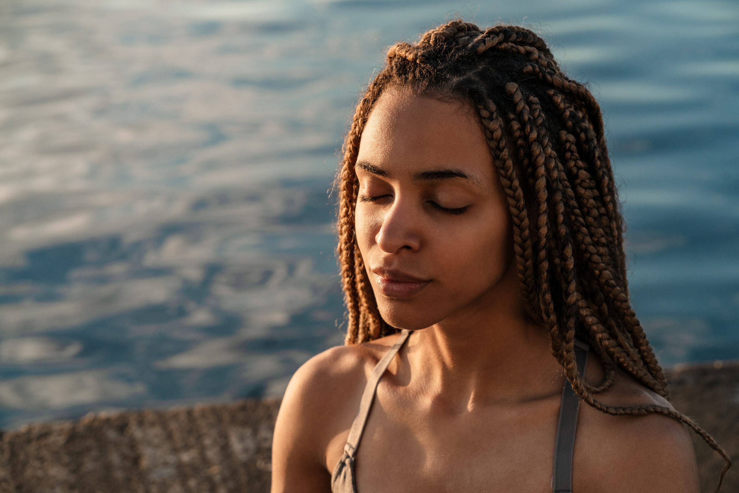 African woman practicing yoga meditation at the beach