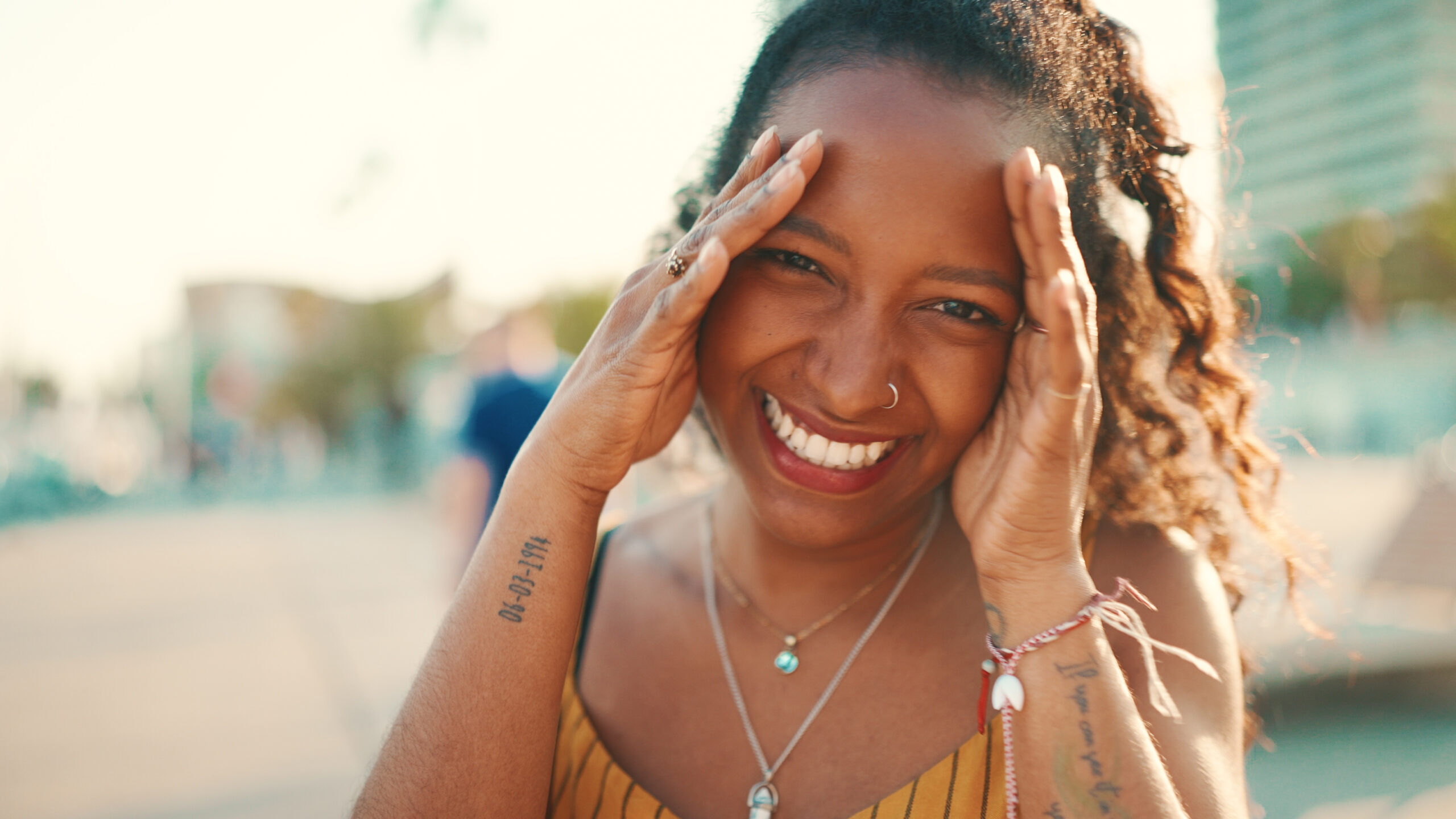 Closeup portrait of smiling woman with long curly hair on urban
