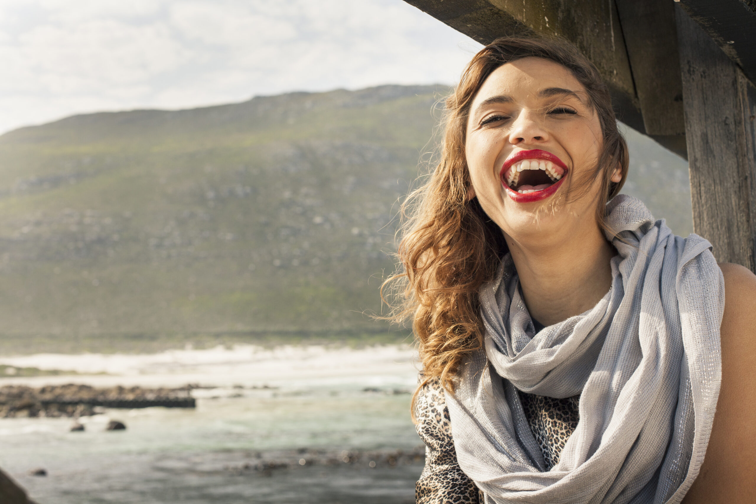 Young woman laughing on coastal pier, Cape Town, Western Cape, South Africa